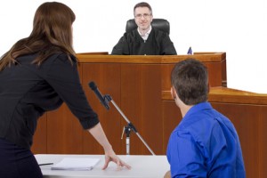 defendant with lawyer speaking to a judge in the courtroom